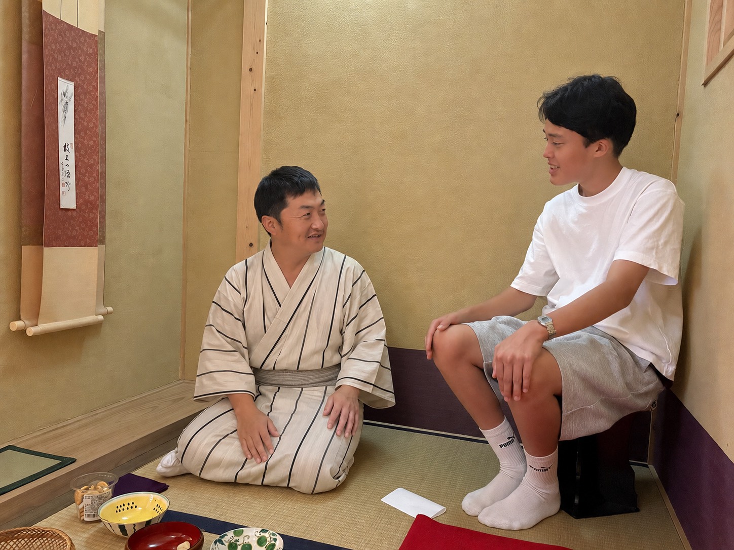 茶室で着物姿の案内役と参加者が話している様子