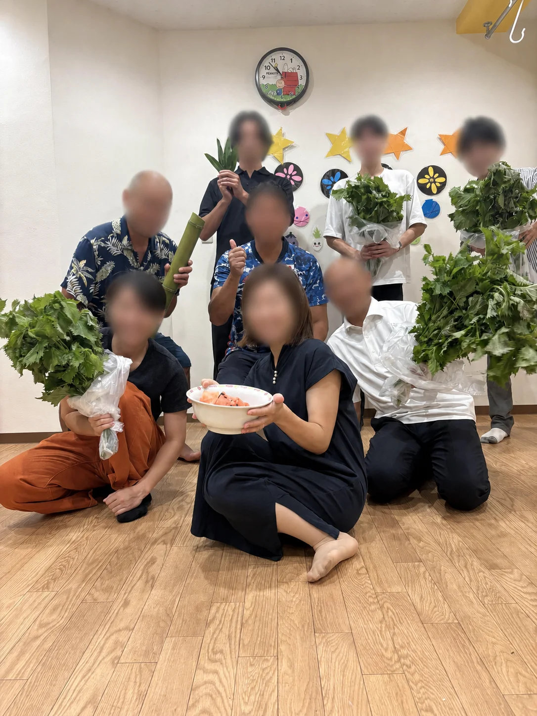 保育園で野菜を手に集まった交流会の参加者たち。顔にはぼかし処理を施しています。